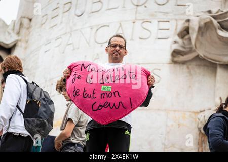 Paris, Frankreich. Mai 2024. Ein Mann zeigt ein Teddyherz, das sagt: "Macron, ich hasse dich aus tiefstem Herzen" auf der Place Republique während der Maivorführung. Rund 200 000 Menschen waren bei den Demonstrationen am 1. Mai, dem Tag der Arbeit, in Paris anwesend. Neben der gewerkschaft nahmen auch mehrere Pro-Palästina- und Anti-Olympia-Aktivistengruppen am märz dieses Jahres Teil. Mehrere Zusammenstöße mit der Polizei wurden auf der Strecke zwischen Place de Republique und Place de Nation aufgezeichnet. Quelle: SOPA Images Limited/Alamy Live News Stockfoto