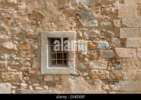 Alte Steinmauer mit einem kleinen Fenster Stockfoto
