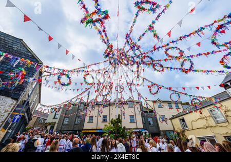Unter der farbenfrohen Maische versammeln sich Menschenmassen zum „Obby Oss Festival“, einem traditionellen Volksfest am Maitag in Padstow, Cornwall, England Stockfoto