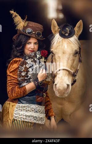 Porträt einer jungen Frau und ihrem Palomino-Pferd Cosplay in einem Steampunk-Outfit Stockfoto