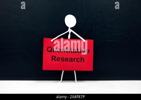 Quantitatives Forschungskonzept. Eine menschliche Stabfigur hält ein rotes Plakatpapier mit geschriebenem Text. Stockfoto
