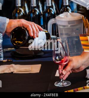 USA, Washington State, Walla Walla. Ein Mann gießt Rotwein in ein Glas bei einer Weinveranstaltung in Walla Walla. (Nur Für Redaktionelle Zwecke) Stockfoto