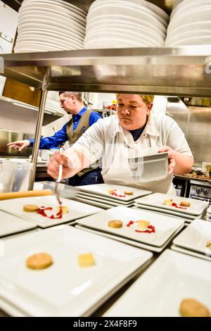 USA, Washington State, Woodinville. Küchenchefin Breanna Beike bereitet bei einem Abendessen mit Winzern im Heritage Restaurant und Bar Gerichte zu. (Nur Für Redaktionelle Zwecke) Stockfoto