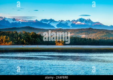 Die schneebedeckten südalpen von der Okarito Lagune an der Westküste bei Sonnenaufgang Stockfoto