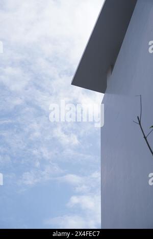 Minimalistische Gebäudefassade mit weißen Wänden vor klarem Himmel Stockfoto