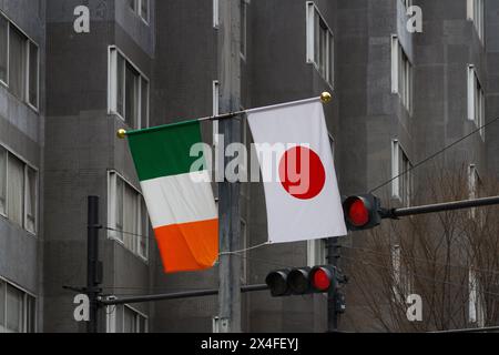 Eine irische und eine japanische Flagge hängen auf der Straße während der 28. St. Patrick's Day Parade in Omotesando, Tokio, Japan. Stockfoto