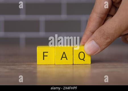 Holzwürfel mit Alphabet FAQ. Konzept für häufig gestellte Fragen. Stockfoto