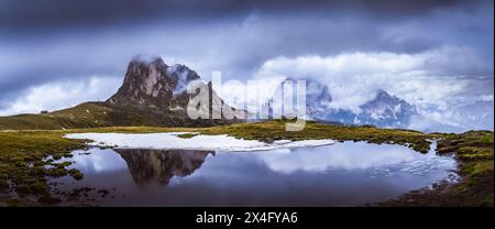 Panoramablick auf die Felsformation mit Reflexion tarn und die Nuvolau Gruppe von Bergen im Hintergrund in den italienischen Dolomiten an bewölktem Tag. Giau Pas Stockfoto