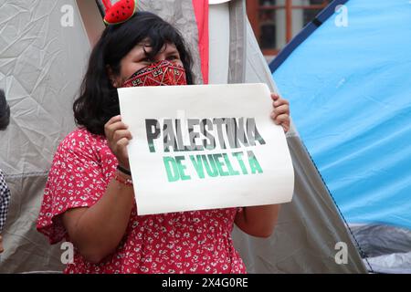 Nicht exklusiv: Ein Student der Universidad Nacional Autonoma de Mexico (UNAM) hält ein Plakat mit der Aufschrift „Palestine Back“ vor einem Zelt in A Stockfoto