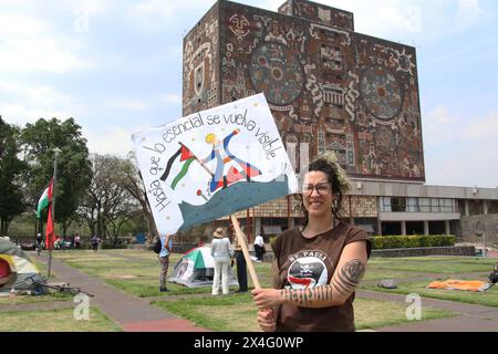 Nicht exklusiv: Eine Studentin der Universidad Nacional Autonoma de Mexico (UNAM) hält ein Plakat vor einem Zelt in einem Lager, um gegen Th zu protestieren Stockfoto