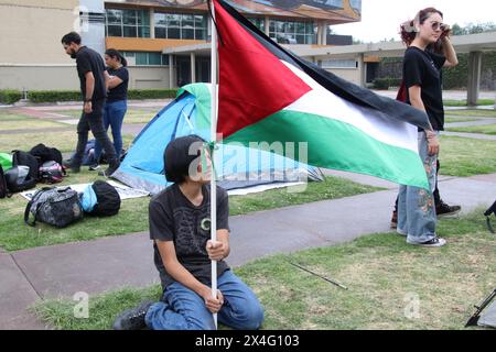 Nicht exklusiv: Student der Universidad Nacional Autonoma de Mexico (UNAM), hält eine palästinensische Flagge, während er ein Zelt in einem Lager aufstellt, um gegen ag zu protestieren Stockfoto