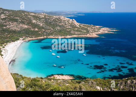 Sartène, Corse-du-Sud, Korsika, Frankreich. Blick auf das türkisfarbene Wasser der Cala di Roccapina von einem felsigen Hügel, Yachten vor Anker in der Bucht. Stockfoto