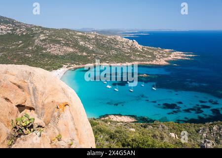 Sartène, Corse-du-Sud, Korsika, Frankreich. Blick auf das türkisfarbene Wasser der Cala di Roccapina von einem felsigen Hügel, Yachten vor Anker in der Bucht. Stockfoto