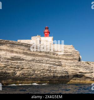 Bonifacio, Corse-du-Sud, Korsika, Frankreich. Blick vom Meer auf die Phare de la Madonetta, den berühmten Leuchtturm auf den Klippen der Stadt. Stockfoto