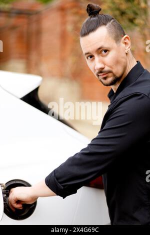 Porträt eines lächelnden Mannes, der in der Nähe des Autos steht Stockfoto