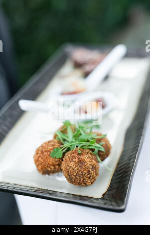 Knusprige Kroketten, elegant präsentiert mit frischen Kräutergarnituren Stockfoto