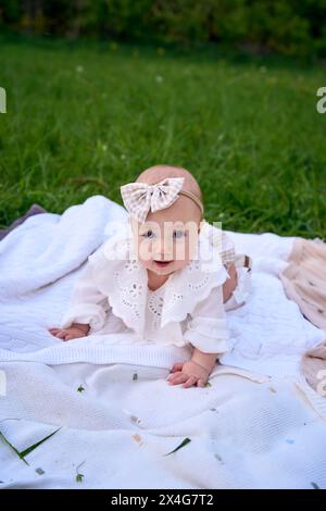 Ein kleines Mädchen kriecht beim Picknick auf der Decke Stockfoto