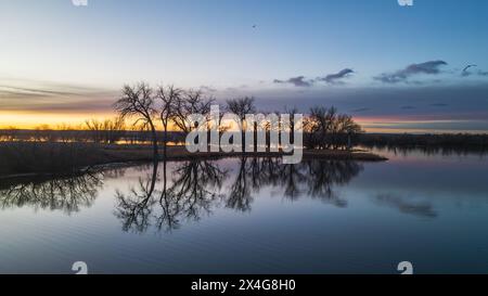 Sonnenaufgang spiegelt sich auf dem ruhigen Wasser Stockfoto