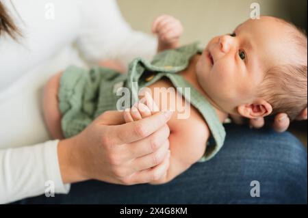 Mutter Hand hält die Hand des Neugeborenen Jungen zu Hause Stockfoto