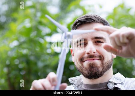 Junger Mann mit Windmühlenmodell in den Händen Stockfoto