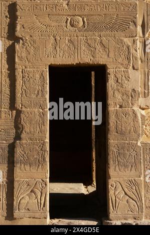 Ägypten. Philae Tempel, der Göttin Isis gewidmet. Errichtet in ptolemäischer und römischer Zeit. Reliefs an einer Tür des Tempels. Oben eine geflügelte Sonnenscheibe. Agilkia Island. Assuan. Stockfoto