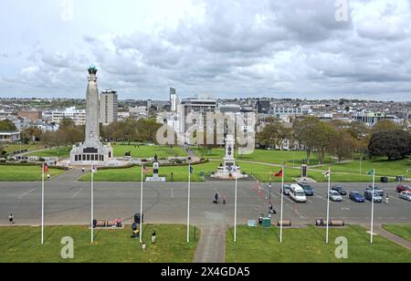 Flaggen säumen die Promenade auf Plymouth Hoe mit dem war Memorial und anderen Staues im Vordergrund und dem Stadtzentrum in der Ferne Stockfoto