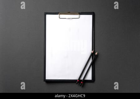 Leeres A4-Papier, das an der Zwischenablage befestigt ist, und Bleistift darauf Stockfoto