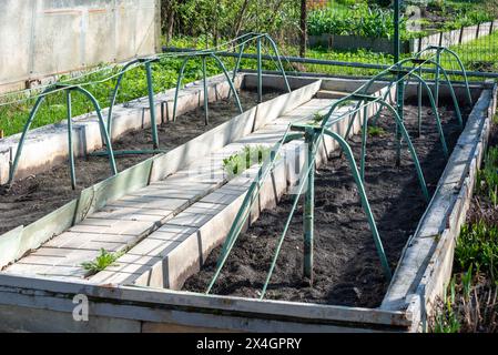 Das niedrige Gewächshaus ist für das Pflanzen von Setzlingen vorbereitet. Gemüsegarten. Stockfoto