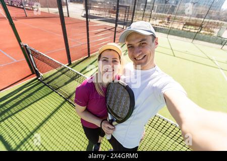 Paddle-Tennis-Team von Frauen und Männern, die im Weitwinkelbild posieren Stockfoto