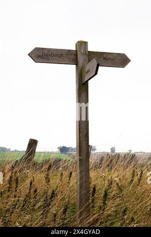 Schilder, die auf Wanderwege nach Roxburgh, Kelso und Heiton in der Region Scottish Borders zeigen. Das Schild ist aus Holz. Stockfoto