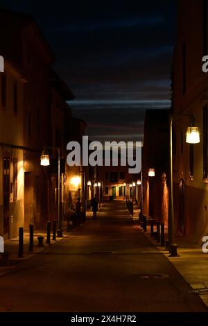 Nächtliche Straßenszene mit warmer Laterne, die die ruhige, enge Gasse beleuchtet und den Charme eines friedlichen Abends in der Stadt einfängt, Highlighti Stockfoto