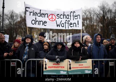 Friedensdemo Nein zu Kriegen DEU, Deutschland, Deutschland, Berlin, 25.11.2023 Demonstranten mit Transparent Frieden schaffen ohne Waffen auf der Demonstration der deutschen Friedensbewegung unter dem Motto Nein zu Kriegen Ruestungswahnsinn stoppen Zukunft friedlich und gerecht gestalten die Waffen nider für Frieden und eine soziale Friedenspolitik am Brandenburger Tor in Berlin Deutschland . Der Protest fordert einen Waffenstillstand in Gaza , Friedensverhandlungen und Ende der Sanktionen gegen Russland , Ende der Waffenlieferungen an die Ukraine und allgemein gegen Aufruestung en: Demonstrat Stockfoto