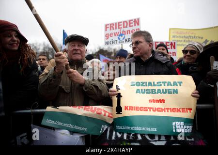 Friedensdemo Nein zu Kriegen DEU, Deutschland, Deutschland, Berlin, 25.11.2023 Demonstrant mit Schild Sozialstatt ausbauen statt Kriegstuechtigkeit gegen das Zitat von Bundesverteidigungsminister Boris Pistorius zu kriegstuechtig auf der Demonstration der deutschen Friedensbewegung unter dem Motto Nein zu Kriegen Ruestungswahnsinn stoppen Zukunft friedlich und gerecht gestalten die Waffen nider für Frieden und eine soziale Friedenspolitik am Brandenburger Tor in Berlin Deutschland . Der Protest fordert einen Waffenstillstand in Gaza , Friedensverhandlungen und Ende der Sanktionen gegen Russlan Stockfoto