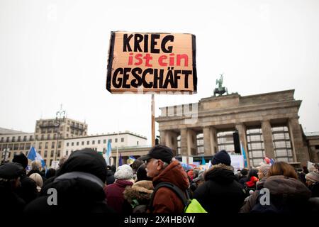 Friedensdemo Nein zu Kriegen DEU, Deutschland, Deutschland, Berlin, 25.11.2023 Demonstranten mit Schild Krieg ist ein Geschaeft Geschäft auf der Demonstration der deutschen Friedensbewegung unter dem Motto Nein zu Kriegen Ruestungswahnsinn stoppen Zukunft friedlich und gerecht gestalten die Waffen nider für Frieden und eine soziale Friedenspolitik am Brandenburger Tor in Berlin Deutschland . Der Protest fordert einen Waffenstillstand in Gaza , Friedensverhandlungen und Ende der Sanktionen gegen Russland , Ende der Waffenlieferungen an die Ukraine und allgemein gegen Aufruestung en: Protesters Stockfoto