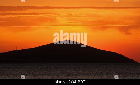 Sonnenuntergang von Bozcaada auf der Ägäischen Insel aus dem Viertel Geyikli in der Stadt Canakkale. Goldene Stunden mit Meer und Insel in Bozcaada. Stockfoto