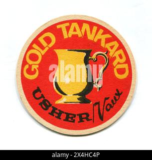 Eine Vintage-Biermatte aus den 1960er Jahren, die für das englische Bier „Gold Tankard“ wirbt, gebraut von Usher/Vaux. Thomas Usher & Son Ltd war eine Brauerei in Edinburgh, Schottland, die 1959 von Vaux, einer großen Brauerei in Sunderland, übernommen wurde. Stockfoto