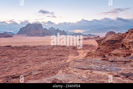 Rot-orangefarbene Marslandschaft in der Jordan Wadi Rum Wüste, Berghintergrund, bedeckt am Morgen. Dieser Ort wurde als Kulisse für viele Science ficti genutzt Stockfoto