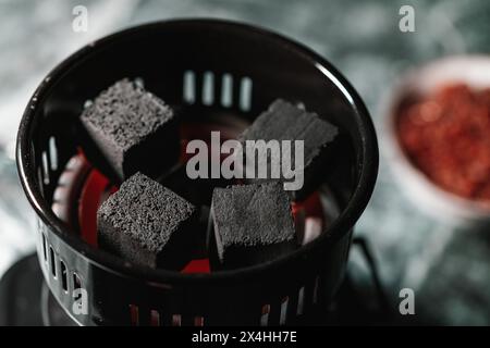 Nahaufnahme von Holzkohlebriketts in einem Grillkorb mit verschwommenem Hintergrund Stockfoto