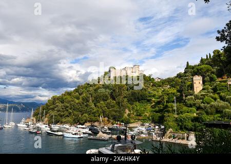 Blick auf den kleinen Hafen ('Porticciolo') des berühmten Ferienortes mit dem Brown Castle auf der Landzunge, Portofino, Genua, Ligurien, Italien Stockfoto