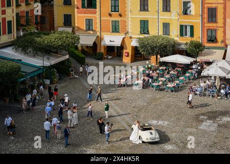 Erhöhter Blick auf die berühmte „Piazzetta“ (kleiner Platz) im Küstendorf, mit einer Braut während des Fotoshootings, Portofino, Genua, Ligurien, Italien Stockfoto