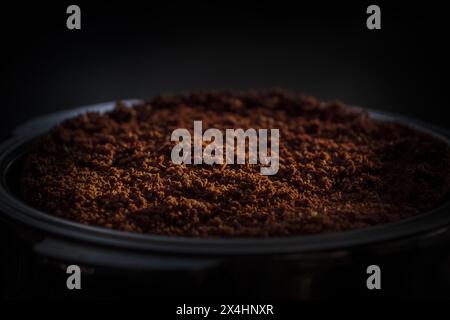 Frisch gemahlener dunkler Röstkaffee in einem Espresso-Portafilter vor dem Stampfen. Dunkle Textur. Stockfoto