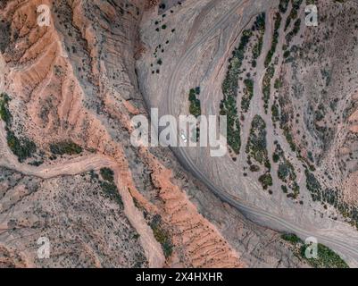 Blick aus der Luft, Geländewagen, Camping im trockenen Flussbett, Blick von oben, Canyon verläuft durch Landschaft, dramatische karge Landschaft mit erodierten Hügeln, Badlands Stockfoto