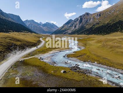 Auto auf der Straße, Bergfluss im grünen Bergtal im Tien Shan Gebirge, Jety Oguz, Kirgisistan Stockfoto