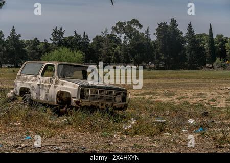 Das kaputte alte Auto auf dem Feld in einer armen Nachbarschaft in Tunis, auf einem schmutzigen Feld an einem heißen Sommertag in Tunesien. Stockfoto