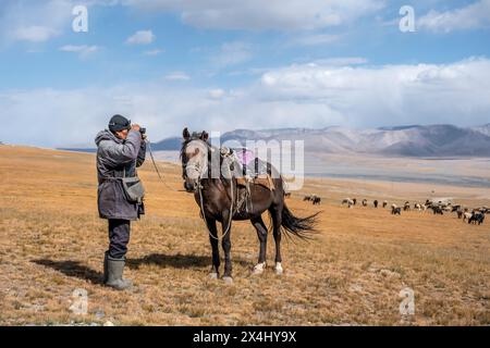 Nomadisches Leben auf einem Hochplateau, Hirte auf Pferd, Schafherde, dramatische hohe Berge, Tian Shan Berge, Jety Oguz, Kirgisistan Stockfoto