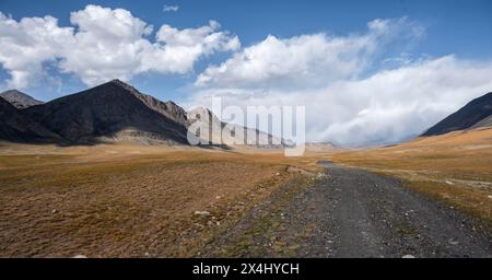 Schotterpiste auf Plateau, dramatische hohe Berge, Tian Shan Berge, Jety Oguz, Kirgisistan Stockfoto