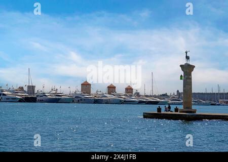 Hirsch Elafos, Skulptur auf einer Säule, am Eingang zum Hafen, im Hintergrund die drei Windmühlen von Rhodos, Mandraki Hafen, Rhodos, Rhodos Stockfoto