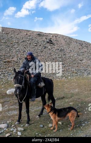 Nomadisches Leben auf einem Plateau, Hirte auf Pferd mit Hund, Tian Shan Berge, Jety Oguz, Kirgisistan Stockfoto