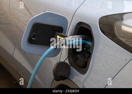 Jerusalem, Israel - 3. März 2023: Ein Elektrokabel, das in die Steckdose eines Elektroautos gesteckt wurde und dessen Batterie auflädt. Stockfoto