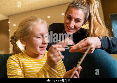 Mutter und Tochter lächeln und sehen sich Ohrringe zusammen drinnen in einem Juweliergeschäft an Stockfoto